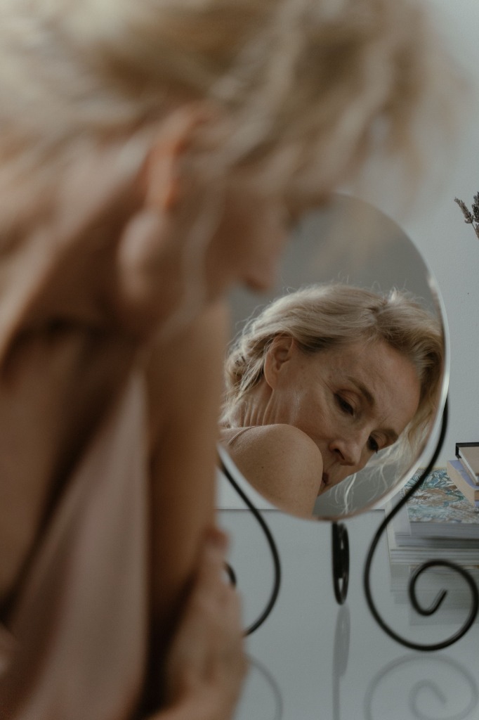 Older woman looking in a vanity mirror